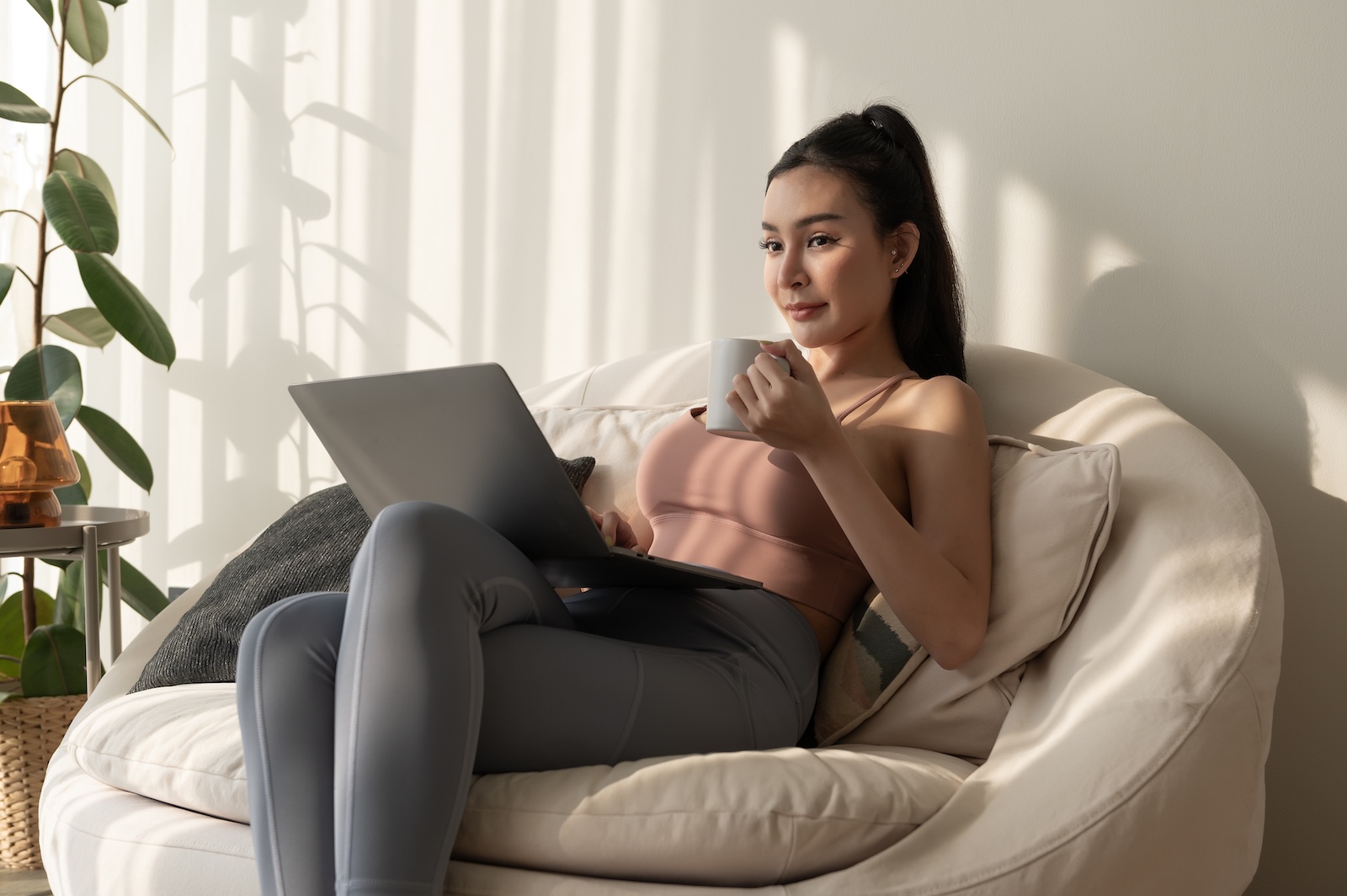 woman working with laptop in living room at home